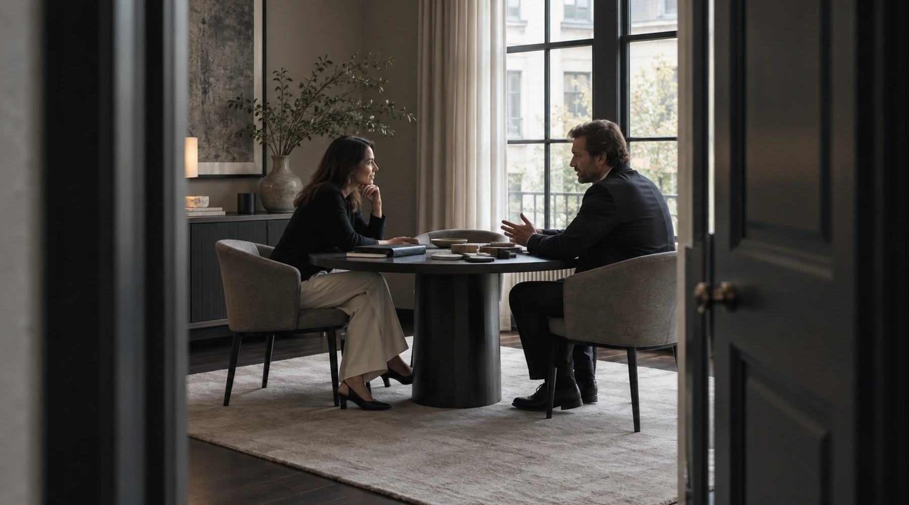 Two people discussing material samples at a round table in an illustrative consultation setting.